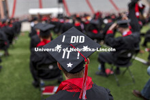 Grad wearing a decorated mortar board that says, “I DID IT!”. The university conferred a record 