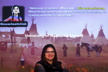 Margaret Huettl, Assistant Professor in History and Ethnic Studies, poses in front of a screen shot 
