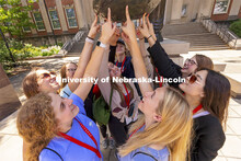 A group of students touch Archie’s foot for good luck as each group made photos for social media. 