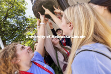 A group of students touch Archie’s foot for good luck as each group made photos for social media. 