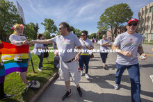 Corrie Svehla hands out a Husker Pride sticker during the Star City Pride parade on June 19. Other m