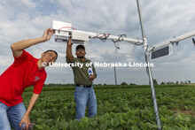 Yufeng Ge and Nipuna Chamara look over a plant remote sensor system being tested at the one-acre fie