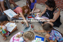 Graduate student Hannah Demma works with campers as they color in their sketches of the Cedar Point 