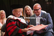 Leta Powell Drake, local television pioneer and Husker alumna, looks over her honorary Doctor of Hum