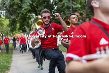 Paul Circo gets some air as the band shows a few moves while marching to the stadium. Big Red Welcom