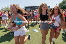 Students run to their chapter during Sorority Rush Bid on the Vine Street fields. Sorority bid day r