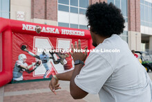 A student throws a football in hopes of winning a free bag during the Big Red Welcome Street Festiva
