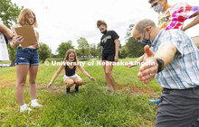 Emily Nelson, a sophomore from Papillion, describes a bed of dandelions to Joe Dauer, associate prof