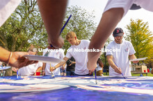 Riley Berner, a senior from Norfolk, is framed by fellow painters working on “Lift Off”. Lift Of