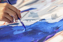 Students paint “Lift Off”, during an entrepreneurial community mural painting in the green space
