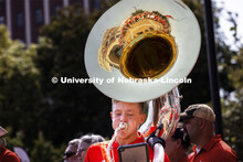 Kason Fiedler, a senior from Lincoln, plays the sousaphone as the Cornhusker Marching Band warms up 