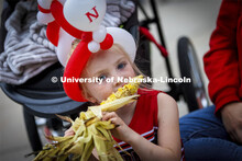 Kennedy Bertsch, 4, of Malcomb, works on an ear of corn while waiting for the parade to begin. Homec