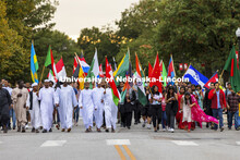 Approximately 100 international students carrying their country’s flags march the parade route. Ho