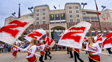 The Cornhusker Marching Band Color Guard march past the Cornstalk Festival crowd at Memorial Stadium