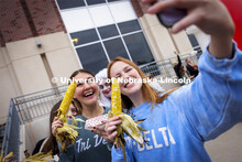 Emma Storms and Erin Stanley pose for a selfie with their Cornstalk Festival roasted corn as Jester 