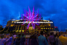 The east side of Memorial Stadium is lit up by the lights of the ferris wheel from the Homecoming Pa