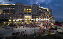 The east side of Memorial Stadium is lit up by the lights of the ferris wheel from the Homecoming Pa
