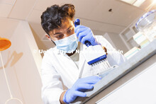 Abdullah Al Mukhaini, junior in forensic science, pipettes a sample in Marc Libault’s lab in Beadl