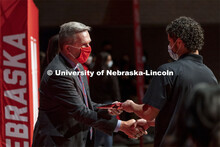 Yael Blanco-Zamudio shakes hands with Chancellor Ronnie Green after receiving his admission certific