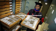 Blessing Ademokoya, a doctoral candidate in entomology, poses with the state museum’s collection o