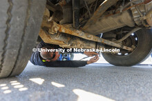 Alex Russell connects the tow cable to a hook under the tractor. Researchers from the Midwest Roadsi