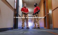 UNLPD Community Service Officers Trevor Caldwell and Komlan Akakpo talk in University Suites hallway