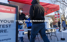 Robert Kelly and other volunteers hand out testing kits to lessen waiting time at the Nebraska Union