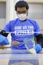 Christian Parrish adds a scoop of beans to a meal being packed. Volunteers are packing more than 2,0