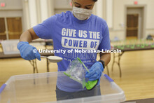 Tristen Williams adds a scoop of rice to a meal being packed. Volunteers are packing more than 2,000