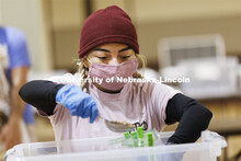 Isela Tercero adds a scoop of beans to a meal being packed in the Nebraska East Union. Nebraska East