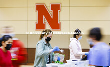 Emmalee Harder adds a scoop of beans to a meal being packed in the Nebraska East Union. Nebraska Eas