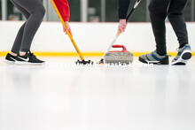 Members of the University of Nebraska Curling Club sweep a curling stone during practice at the John