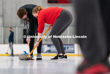 Seamus Hurley (left) and Olivia Schuster (right) sweep a curling stone during practice at the John B