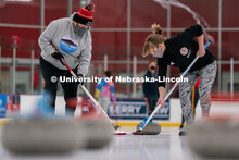 University of Nebraska Curling Club adviser Nancy Myers (left) and Emma Whaley (right) sweep a curli