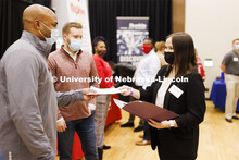 Elizabeth Iverson gives her resume to Gallup recruiters at the UNL Spring Career Fair in the Nebrask