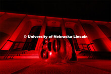 The Sheldon Memorial Art Gallery and Fallen Dreamer sculpture are bathed in red lights for Glow Big 