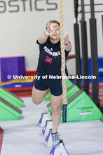 Leigh Jahnke leaps for a rope to swing across an area after running through the quad steps and acros