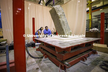 Christine Wittich talks with students as they position a slab on a large shake table in the structur