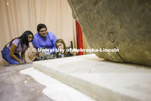 Christine Wittich talks with students as they position a slab on a large shake table in the structur