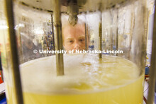 Josiah Kolar examines a bioreactor in Hunter Flodman’s UO Lab. College of Engineering photo shoot.