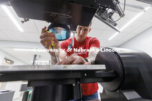 Garrett Beard tightens down a titanium sample that will be laser treated in Craig Zuhlke’s lab. Co