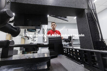 Garrett Beard tightens looks over a titanium sample that will be laser treated in Craig Zuhlke’s l