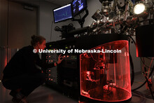 Graham Kaufman adjusts a modular high vacuum laser processing system in Craig Zuhlke’s lab. Colleg