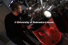 Graham Kaufman adjusts a modular high vacuum laser processing system in Craig Zuhlke’s lab. Colleg