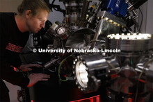 Graham Kaufman adjusts a modular high vacuum laser processing system in Craig Zuhlke’s lab. Colleg