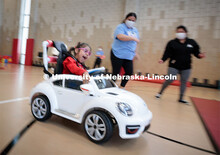 Four-year-old Dayana Torres enjoys the new, battery-powered car that UNL and UNMC students modified 