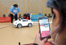 Four-year-old Dayana Torres enjoys the new, battery-powered car that UNL and UNMC students modified 