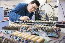 Shuaiqi Shen works on a circuit board in Kuan Zhang’s IoT and AI lab. College of Engineering photo