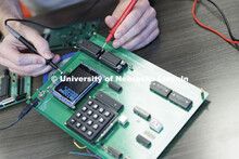 Matthew Boeding tests a board in Hamid Sherif’s Telecom lab. College of Engineering photo shoot at