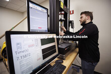 Clayton Malone compresses a sample on the Instron test machine in Jinying Zhu’s lab. College of En